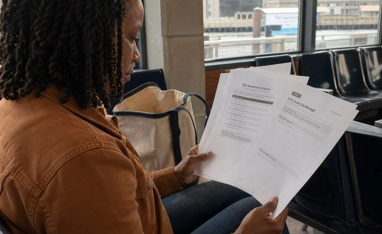 A Black woman reviewing printed pages from the Built for Real Life Season 2 Companion Guide.
